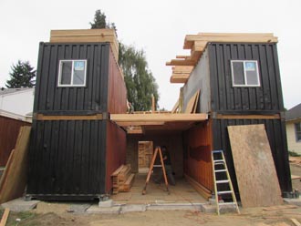 conatiners placed on slab house built around containers